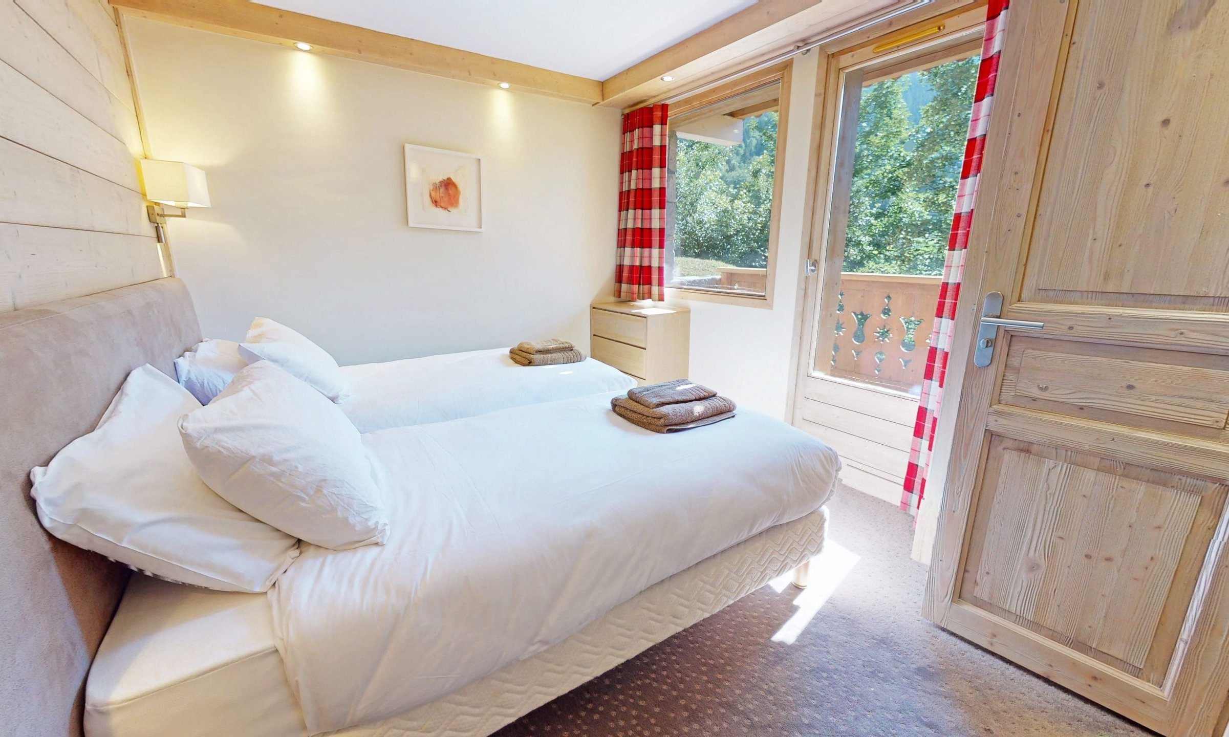 A bedroom with a balcony in Chalet Eleanor Meribel