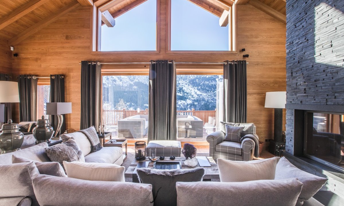 The spacious living room with a fireplace in Chalet Le Grenier Meribel Centre