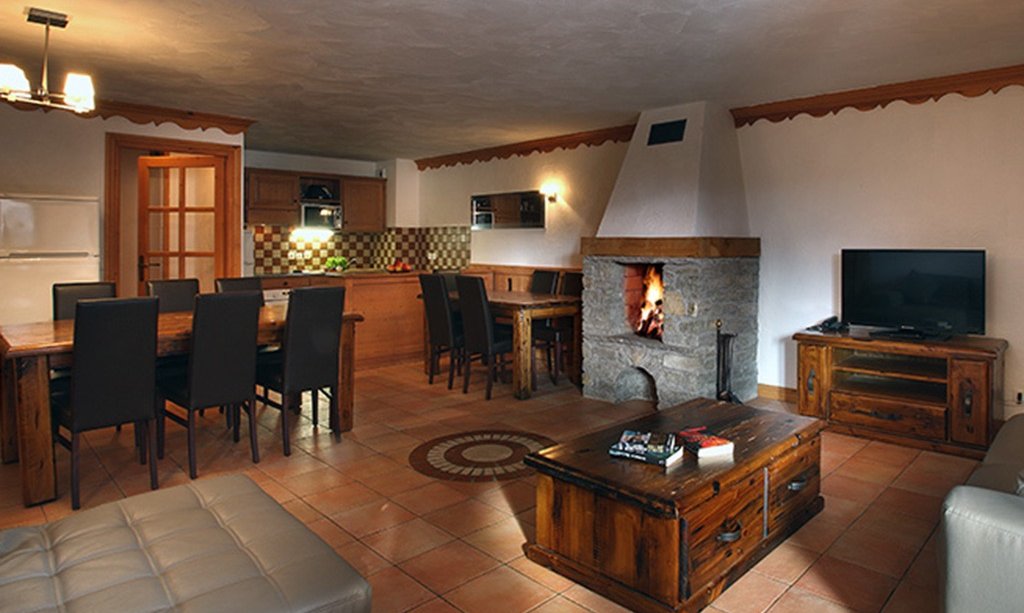 The Living and dining area with fireplace in a Chalet des Neiges Plein Sud apartment Val Thorens