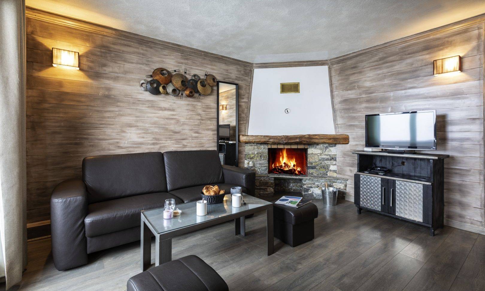 A Living room with fireplace in one of the apartments of Chalet des Neiges Hermine apartments in Val Thorens