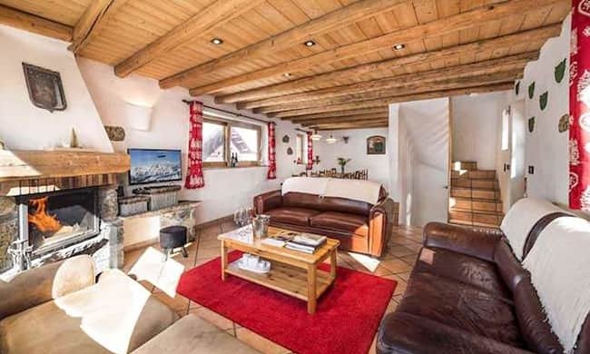 Spacious living room with a fireplace in Chalet Lou Trave Meribel