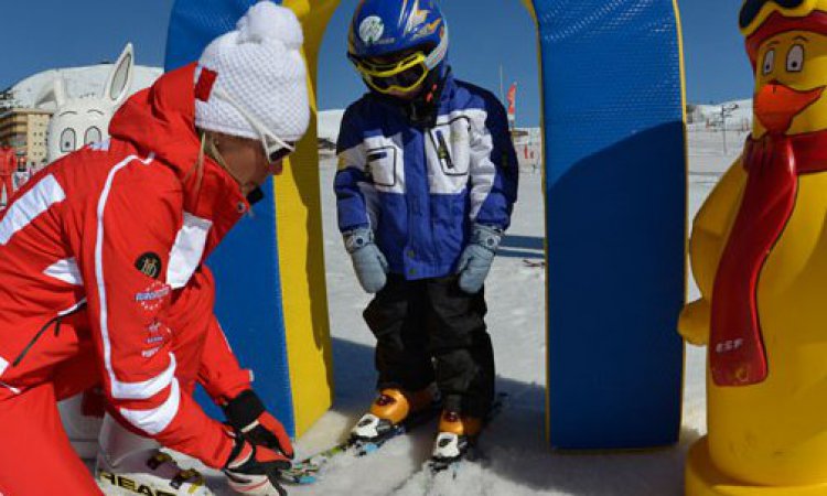 Ski instructor with child and duck