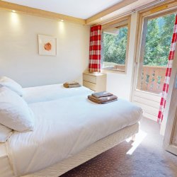 A bedroom with a balcony in Chalet Eleanor Meribel