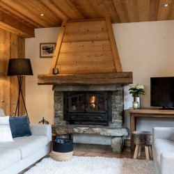 The Living area with a fireplace in Chalet Blanchot Meribel