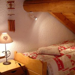 Twin bedroom under eaves in chalet La Fugue Meribel